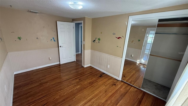 unfurnished room featuring dark hardwood / wood-style floors and a textured ceiling