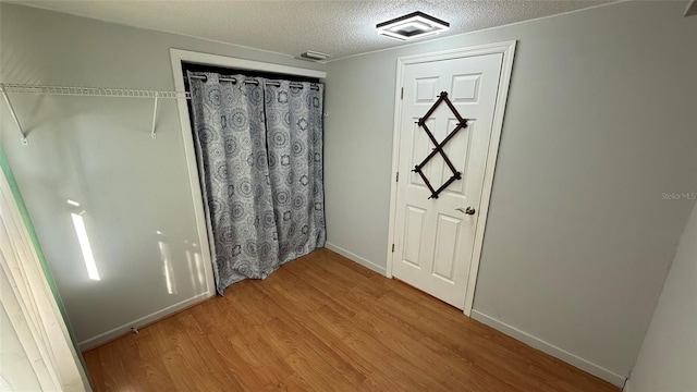 interior space featuring light hardwood / wood-style flooring and a textured ceiling