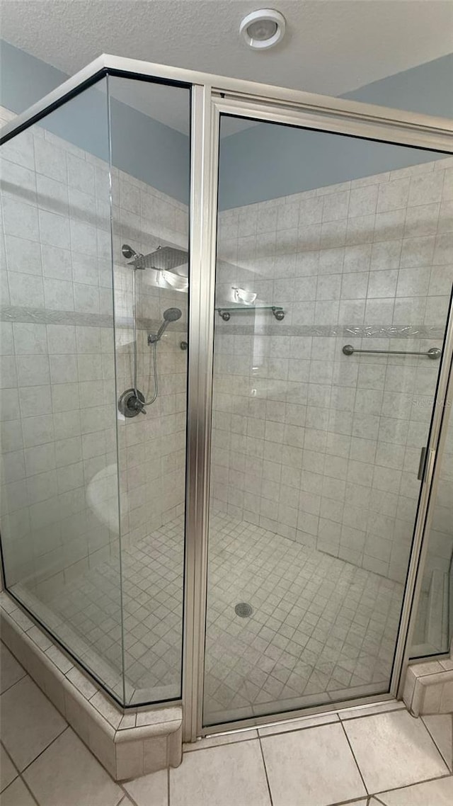 bathroom featuring tile patterned flooring, a textured ceiling, and walk in shower