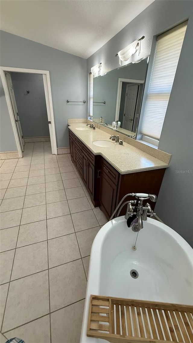 bathroom with vanity, tile patterned flooring, a textured ceiling, and a bathtub