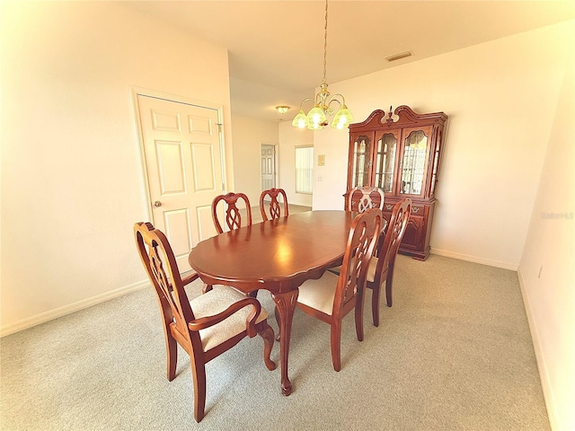 carpeted dining area with an inviting chandelier