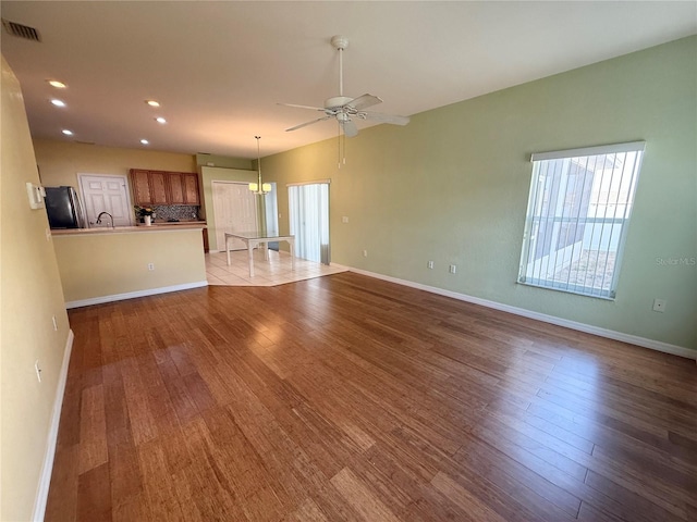 unfurnished living room featuring ceiling fan and light wood-type flooring