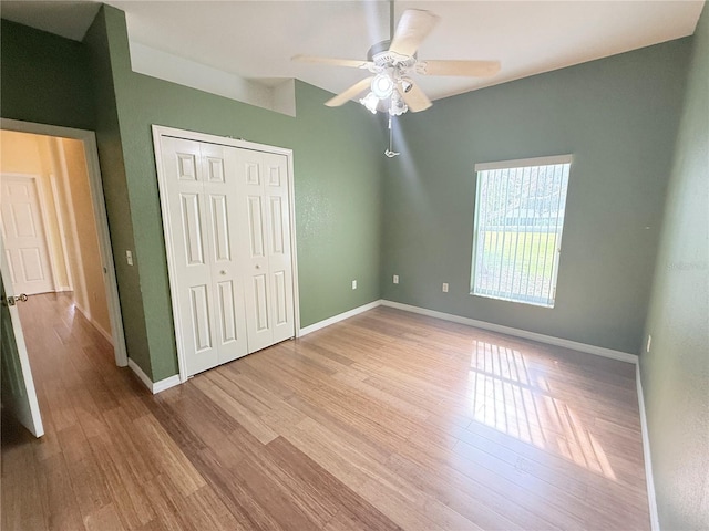 unfurnished bedroom featuring light hardwood / wood-style floors, a closet, and ceiling fan