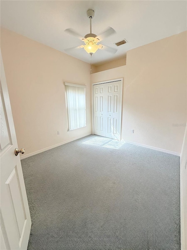 unfurnished bedroom with ceiling fan, carpet flooring, and a closet