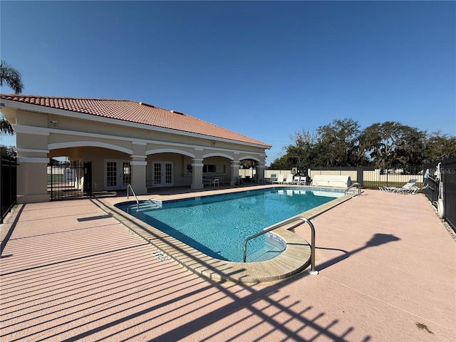 view of swimming pool with french doors and a patio area