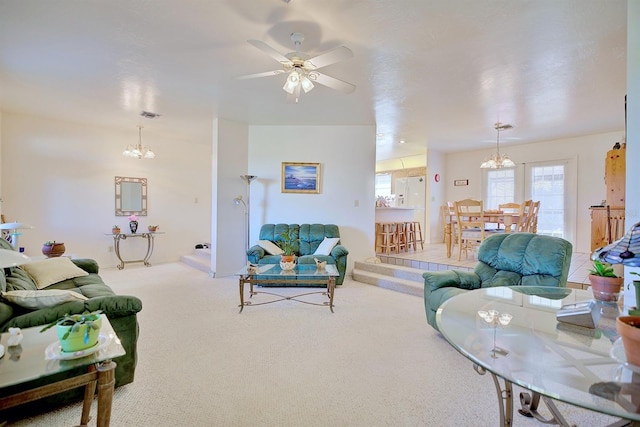 living room featuring ceiling fan with notable chandelier and light carpet