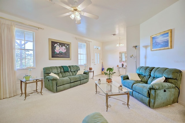 living room with carpet floors, a healthy amount of sunlight, and ceiling fan with notable chandelier