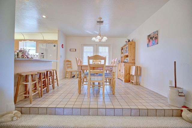 tiled dining room featuring an inviting chandelier