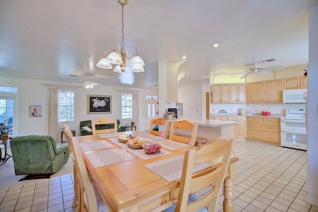 dining room featuring ceiling fan with notable chandelier and light tile patterned floors