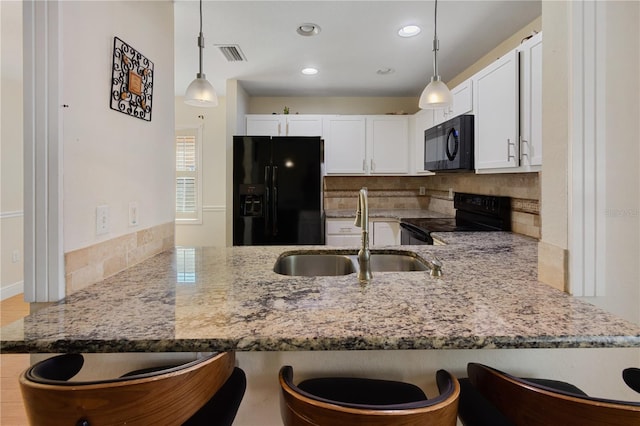 kitchen featuring sink, white cabinetry, hanging light fixtures, black appliances, and kitchen peninsula