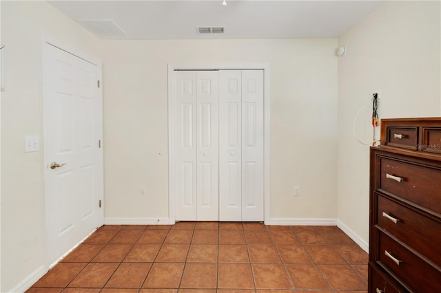 bedroom with tile patterned flooring and a closet