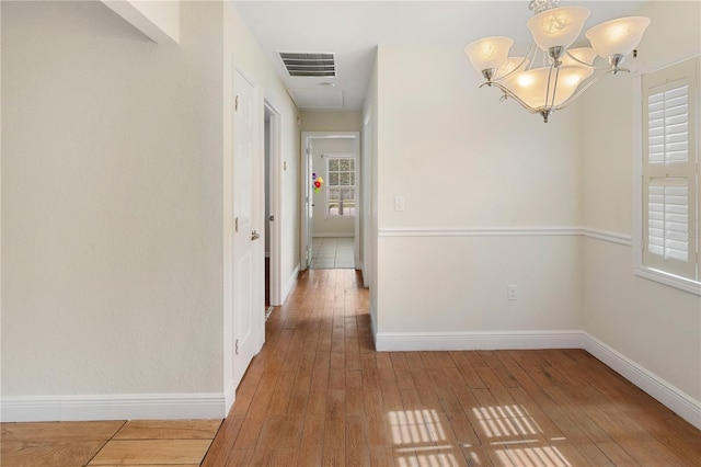 hall featuring hardwood / wood-style flooring and a notable chandelier