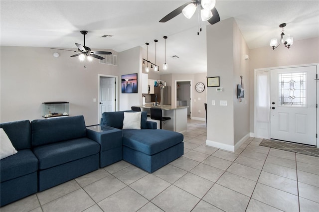 tiled living room featuring vaulted ceiling and ceiling fan with notable chandelier