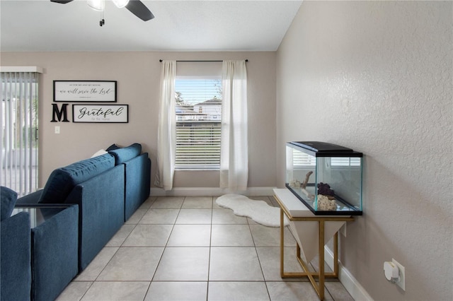 living room with ceiling fan and tile patterned floors