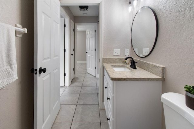 bathroom featuring tile patterned flooring, vanity, and toilet