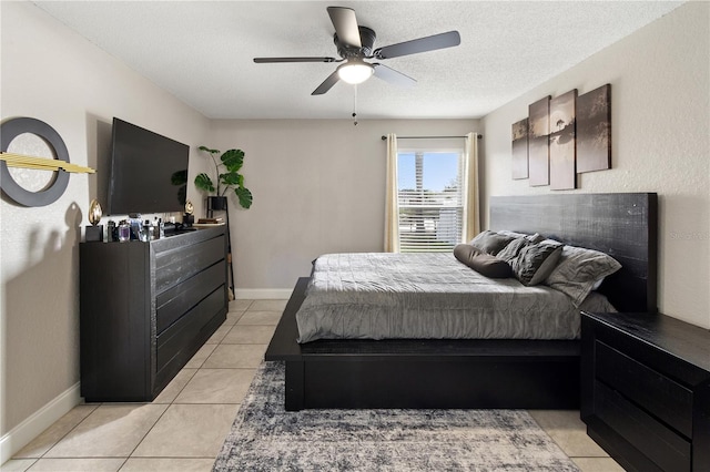 tiled bedroom with ceiling fan and a textured ceiling