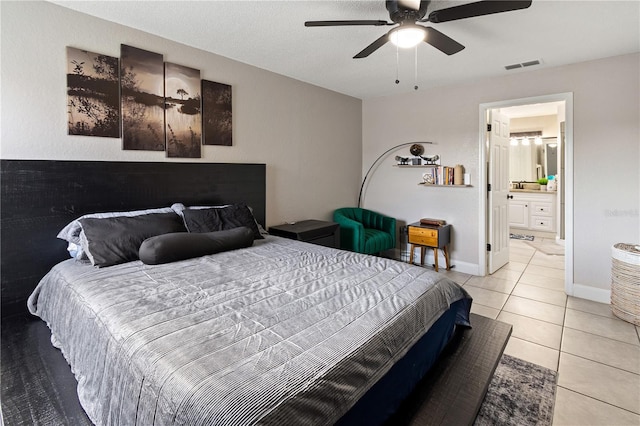 bedroom featuring ensuite bathroom, light tile patterned floors, and ceiling fan