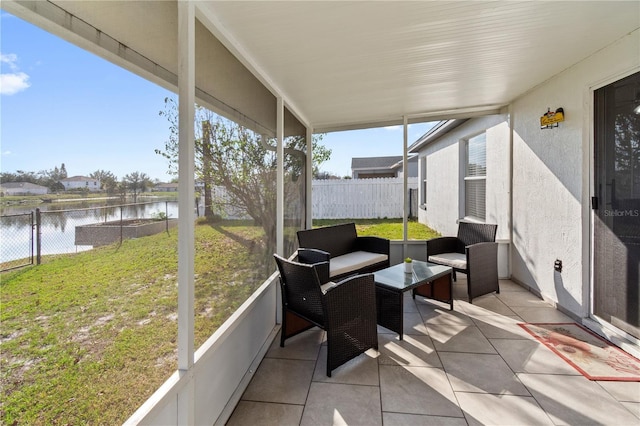 sunroom featuring a water view