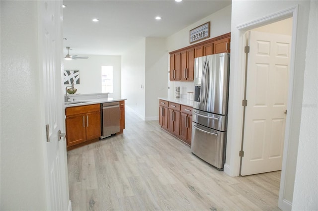 kitchen featuring sink, light hardwood / wood-style flooring, stainless steel appliances, and ceiling fan