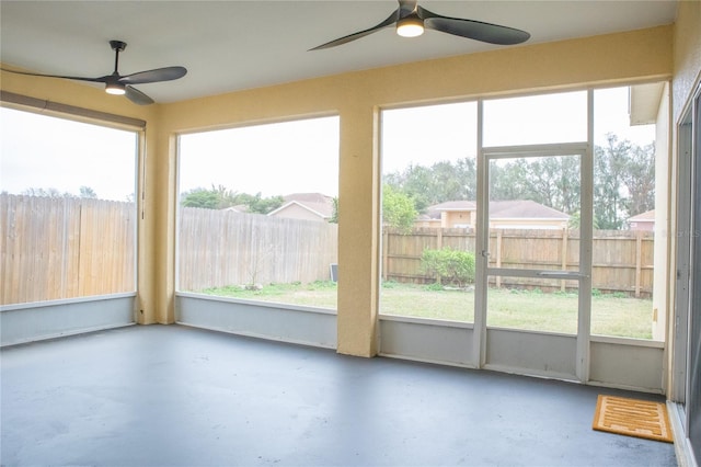 unfurnished sunroom with ceiling fan