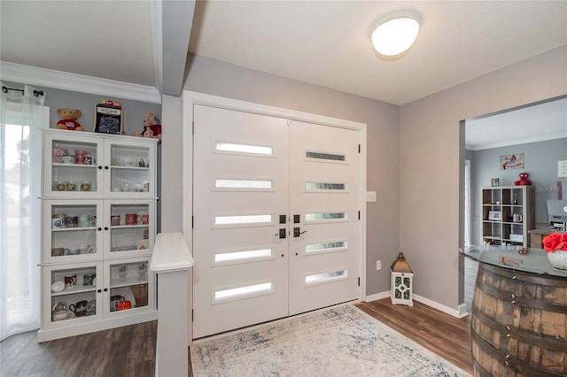 entrance foyer with crown molding, baseboards, and wood finished floors