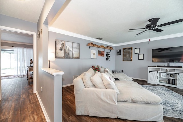 living room featuring ceiling fan, ornamental molding, dark hardwood / wood-style flooring, and a textured ceiling