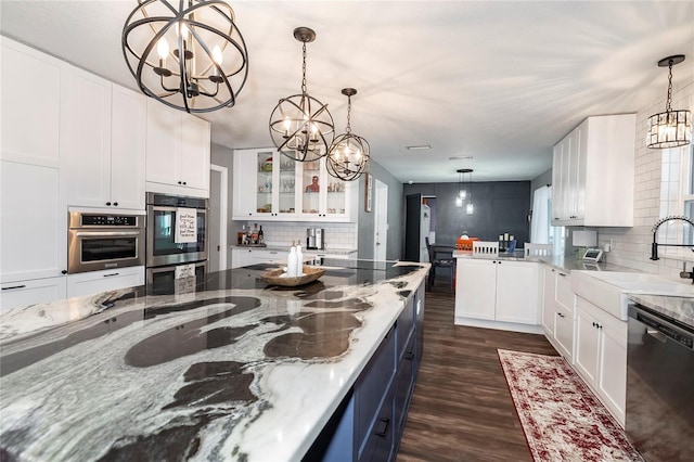 kitchen featuring an inviting chandelier, white cabinets, and dishwasher