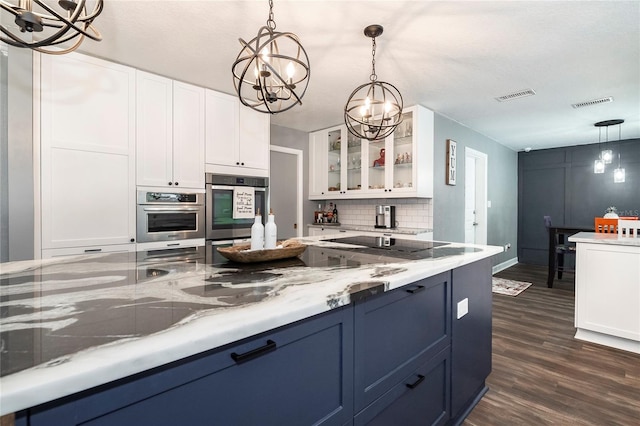 kitchen with dark hardwood / wood-style floors, pendant lighting, white cabinetry, decorative backsplash, and an inviting chandelier