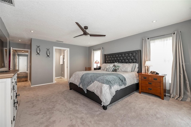 carpeted bedroom featuring ceiling fan and a textured ceiling