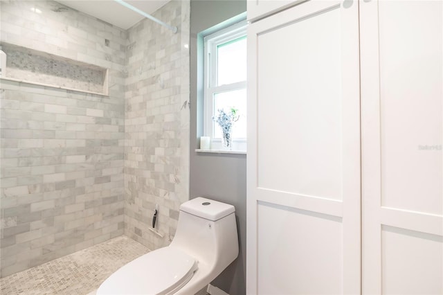 bathroom with tiled shower and toilet