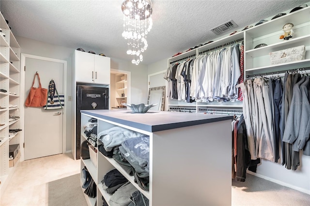 walk in closet featuring light carpet and a notable chandelier