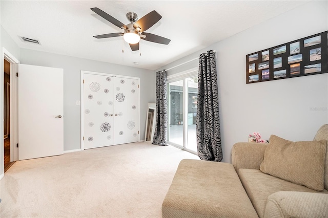 sitting room featuring light colored carpet and ceiling fan