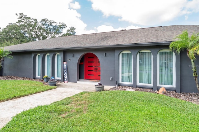 single story home featuring roof with shingles, a front lawn, and stucco siding