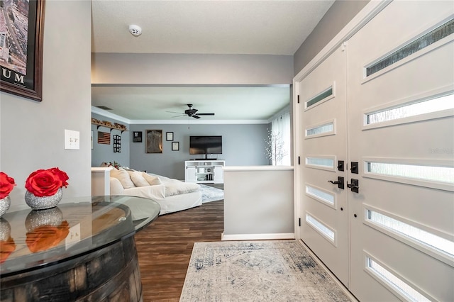 foyer featuring dark wood-style floors, crown molding, and ceiling fan