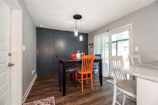 dining area featuring dark wood finished floors and baseboards