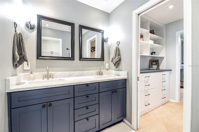 full bath featuring double vanity, baseboards, and a sink