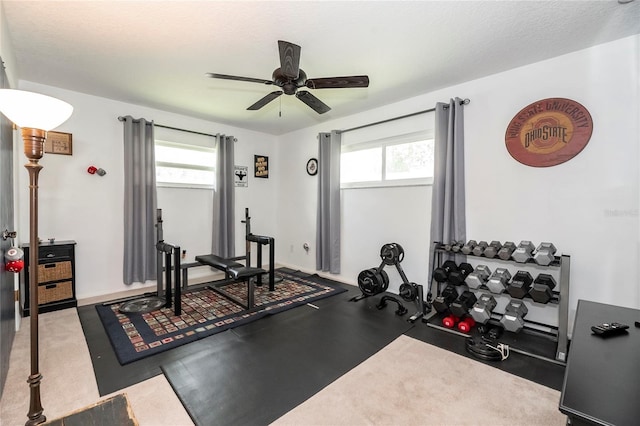 workout area featuring ceiling fan and baseboards