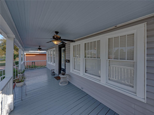 wooden terrace featuring covered porch and ceiling fan