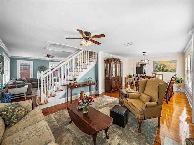 living room with crown molding, ceiling fan, and light hardwood / wood-style flooring