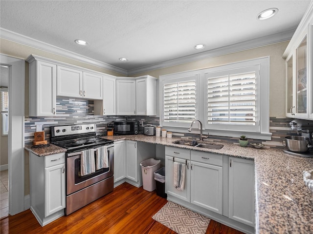 kitchen with white cabinetry, stainless steel range with electric stovetop, light stone countertops, and sink