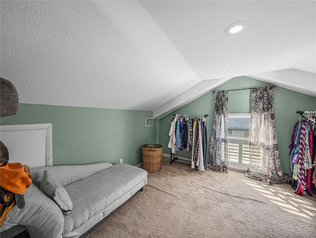 interior space featuring lofted ceiling, carpet, and a textured ceiling