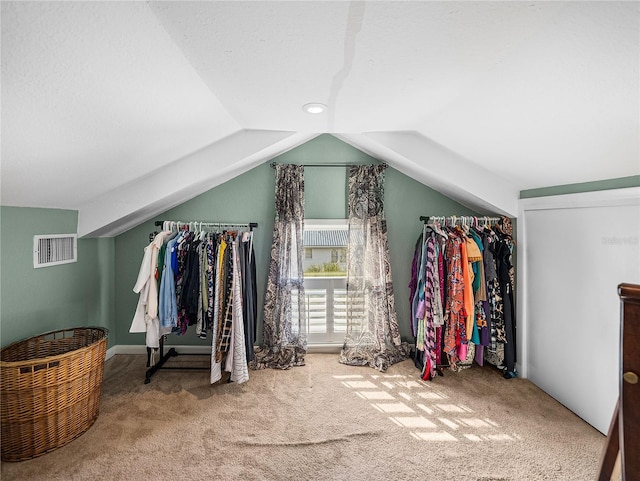 walk in closet with vaulted ceiling and carpet