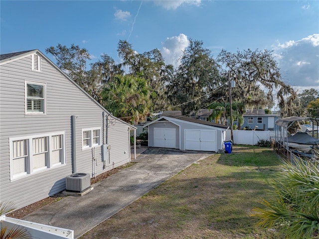 view of side of property with cooling unit, a yard, a garage, and an outdoor structure