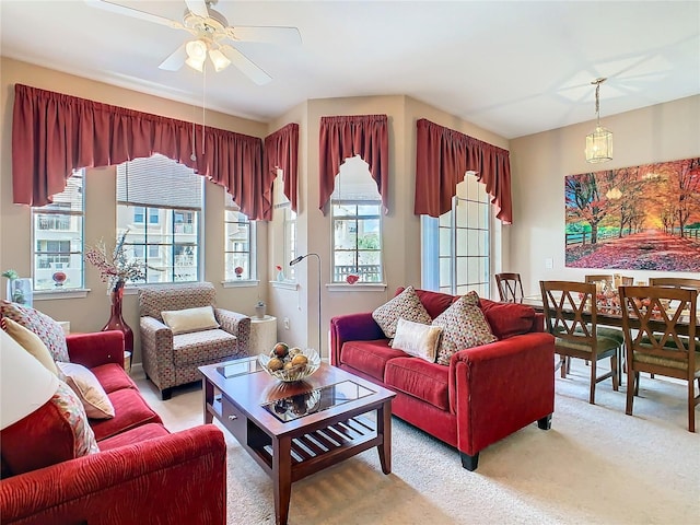 carpeted living room with ceiling fan