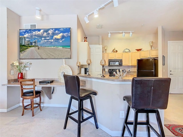 205 Terrace Ridge Cir Unit 205, Davenport, FL 33896 - kitchen featuring a breakfast bar, black appliances, track lighting, kitchen peninsula, and cream cabinetry