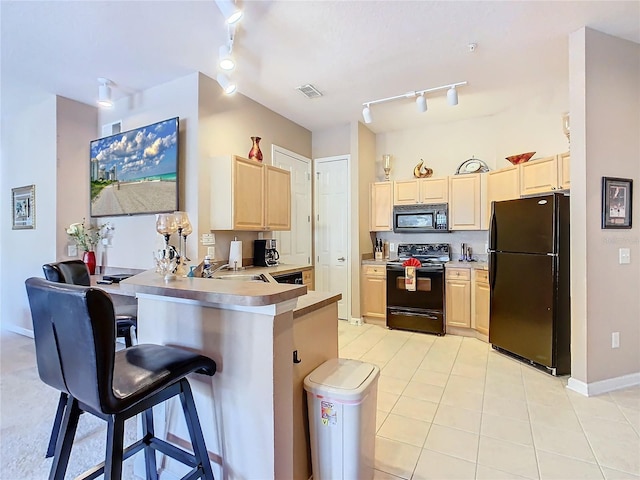 205 Terrace Ridge Cir Unit 205, Davenport, FL 33896 - kitchen with kitchen peninsula, light brown cabinetry, a kitchen bar, and black appliances