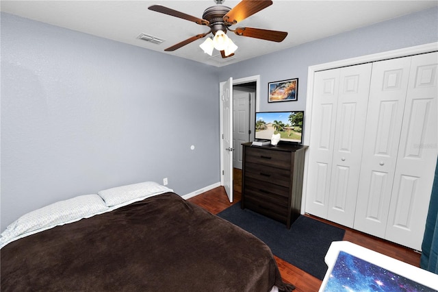 bedroom with dark wood-type flooring, a closet, and ceiling fan