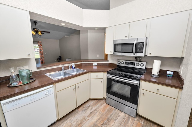 kitchen featuring appliances with stainless steel finishes, white cabinetry, sink, ceiling fan, and light wood-type flooring