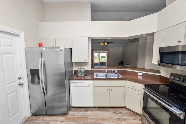 kitchen featuring sink, light wood-type flooring, appliances with stainless steel finishes, ceiling fan, and white cabinets