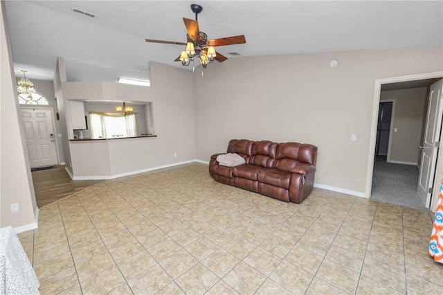 living room featuring ceiling fan with notable chandelier, lofted ceiling, and light tile patterned floors